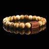 Handmade picture jasper beaded bracelet with sandy brown and tan landscape patterns and a dark wood engraved 'JASE' logo block, shown on a reflective black surface.